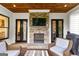 Covered patio with stone fireplace, TV, and comfortable seating, accessible by dual sets of french doors at 215 Sheridan Ln, Peachtree City, GA 30269