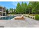 Relaxing lounge area with chairs and umbrella overlooking the large pool and back of house at 215 Sheridan Ln, Peachtree City, GA 30269
