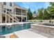 Swimming pool and spa with in-pool lounge chairs and a view of the house with screened porch at 215 Sheridan Ln, Peachtree City, GA 30269