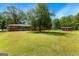Large backyard with green grass and outbuilding with brick home in the background at 270 Lake Cir, Fayetteville, GA 30215