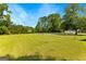 Large backyard, fully fenced, with a glimpse of a body of water and gazebo in the distance at 270 Lake Cir, Fayetteville, GA 30215