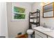 A well-lit bathroom with a large window and wooden floors, featuring a white countertop and modern toilet at 270 Lake Cir, Fayetteville, GA 30215