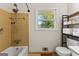 The bathroom features a bathtub with showerhead, a toilet, a large window, and open shelving at 270 Lake Cir, Fayetteville, GA 30215