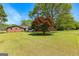 Scenic view of a brick house with a vast lawn and mature trees under a clear blue sky at 270 Lake Cir, Fayetteville, GA 30215