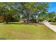 Expansive lawn highlights a charming single-story home under a canopy of mature trees at 270 Lake Cir, Fayetteville, GA 30215