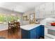 Kitchen open to dining area, featuring white upper cabinets, blue lower cabinets, and warm lighting at 270 Lake Cir, Fayetteville, GA 30215
