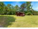 Exterior shot of a red outbuilding, set on a green lawn, and surrounded by trees at 270 Lake Cir, Fayetteville, GA 30215