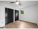 Bright bedroom featuring wood floors, a ceiling fan and built-in closet with black doors at 410 Queen Aliese Ln, Jonesboro, GA 30236