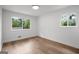 A clean and bright bedroom features wood flooring and two windows for natural light at 410 Queen Aliese Ln, Jonesboro, GA 30236