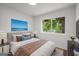 Staged bedroom features natural light, an accent wall-mounted TV, and stylish furniture at 410 Queen Aliese Ln, Jonesboro, GA 30236