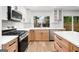 Modern kitchen with white cabinets, quartz countertops, stainless steel appliances and hardwood floors at 410 Queen Aliese Ln, Jonesboro, GA 30236