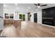 Bright, open-concept living room with modern lighting, hardwood floors, and open layout into kitchen at 410 Queen Aliese Ln, Jonesboro, GA 30236