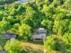 Property aerial view highlighting the residence nestled among mature trees in a tranquil setting at 115 Linda Way, Fayetteville, GA 30215