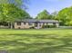 Beautiful one-story brick home with a spacious front lawn and mature trees at 115 Linda Way, Fayetteville, GA 30215