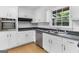 A well-lit kitchen with white cabinets, stainless steel appliances and dark countertops offers a practical and inviting space at 115 Linda Way, Fayetteville, GA 30215