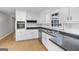 A well-lit kitchen featuring white cabinets, stainless steel appliances and light wood floors create a bright and airy space at 115 Linda Way, Fayetteville, GA 30215