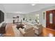 Staged living and dining area with neutral furniture, laminate floors, and large windows at 115 Linda Way, Fayetteville, GA 30215