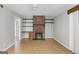 Spacious living room with wood-look floors, brick fireplace, and desk/shelving unit offers comfort and functionality at 115 Linda Way, Fayetteville, GA 30215