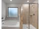 Well-lit bathroom featuring a bathtub and shower combination with neutral tiling at 1816 Quaker St, Hampton, GA 30228