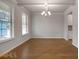 Bright dining room features hardwood floors, a modern chandelier, and lots of natural light from large windows at 1816 Quaker St, Hampton, GA 30228