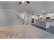 Open-concept living room featuring modern staircase and adjacent kitchen with stainless steel appliances at 1816 Quaker St, Hampton, GA 30228