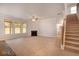 A living room features a fireplace, ceiling fan, stairs, and multiple windows bringing in natural light at 1816 Quaker St, Hampton, GA 30228