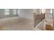 Upstairs loft area with neutral carpet, natural light, and a railing overlooking the downstairs area at 1816 Quaker St, Hampton, GA 30228