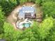 Overhead view of a home surrounded by lush greenery with a backyard pool and a spacious deck at 95 Weslyan Way, Oxford, GA 30054