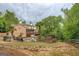 Brick home with a large backyard, pool, stone waterfall, and a spacious deck overlooking the lush green landscape at 95 Weslyan Way, Oxford, GA 30054