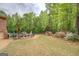 Large backyard featuring lush greenery, flower beds, expansive lawn, and a private pool with lounge seating at 95 Weslyan Way, Oxford, GA 30054
