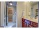 Bathroom featuring a wood vanity, a framed mirror, and an adjacent shower room at 95 Weslyan Way, Oxford, GA 30054