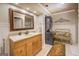 Spacious bathroom features a wooden vanity, framed mirror, and stacked washer and dryer at 95 Weslyan Way, Oxford, GA 30054