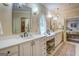 This luxurious bathroom has dual sinks, a vanity, sconces, and a decorative window at 95 Weslyan Way, Oxford, GA 30054