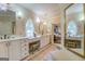This luxurious bathroom has dual sinks, a vanity, sconces, and a decorative window at 95 Weslyan Way, Oxford, GA 30054