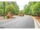 Grand entrance to a gated community with brick pillars, black iron gates, and mature landscaping at 95 Weslyan Way, Oxford, GA 30054