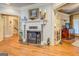 A bright living room with hardwood floors has an ornate fireplace and double doors to another room at 95 Weslyan Way, Oxford, GA 30054