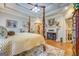 This primary suite features a tray ceiling, a decorative fireplace, and hardwood floors at 95 Weslyan Way, Oxford, GA 30054