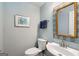 Stylish half bathroom featuring blue walls, decorative mirror, and modern fixtures at 5 Renfroe Ct, Decatur, GA 30030