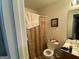 Modest bathroom featuring toilet, curtained bathtub and toiletries on the sink at 1255 Chinon Pt, Lithonia, GA 30058