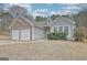 View of the house's side with garage and the front entrance featuring stone detail and manicured landscaping at 131 Meadowbrook Ln, Grantville, GA 30220