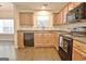 Bright kitchen boasting wood cabinets, granite countertops, and black appliances at 131 Meadowbrook Ln, Grantville, GA 30220