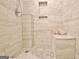 Modern shower with neutral colored wall tile, hexagon floor tiles, and a built-in shower bench at 131 Meadowbrook Ln, Grantville, GA 30220