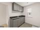 Laundry room with gray cabinets, granite countertops, tile floors, and natural lighting from window at 1817 Quaker St, Hampton, GA 30228