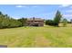 Expansive backyard with lush green lawn, mature trees, and a view of the home's exterior at 127 Grayson Myers Dr, Villa Rica, GA 30180