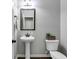 Stylish half bath with pedestal sink, decorative mirror, and modern fixtures at 127 Grayson Myers Dr, Villa Rica, GA 30180