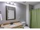 Bathroom with granite-topped vanity, decorative mirror, and a shower with green curtain at 127 Grayson Myers Dr, Villa Rica, GA 30180
