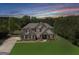 Beautiful two-story home with lush lawn and mature trees against a dramatic twilight sky at 127 Grayson Myers Dr, Villa Rica, GA 30180