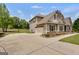 A driveway leads to the garage of a light-brown two-story house with dark trim and a basketball hoop at 127 Grayson Myers Dr, Villa Rica, GA 30180