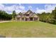 Expansive green lawn in front of a beautiful two story house with light brown siding and dark trim at 127 Grayson Myers Dr, Villa Rica, GA 30180