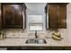 Close-up of kitchen sink and window with dark cabinetry and granite counters at 127 Grayson Myers Dr, Villa Rica, GA 30180